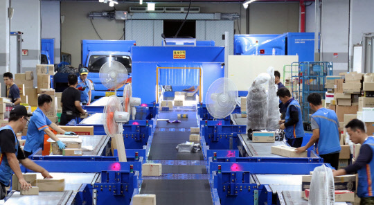 CJ대한통운이 10일부터 약 5주 간을 추석 명절 특별수송기간으로 정하고 비상근무에 들어간다. CJ대한통운 택배 터미널에서 휠소터로 자동 분류한 택배 상자를 배송 담당자들이 정리하고 있다.  CJ대한통운 제공